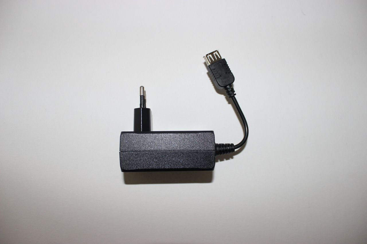 Das Bild zeigt ein schwarzes Netzteil der Marke Chihiros mit einem fest verbundenen Kabel. Das Netzteil verfügt über einen Standardstecker und einen USB-Anschluss am Kabelende. Es liegt auf einer weißen, neutralen Oberfläche. Das Produkt ist kompakt und f
