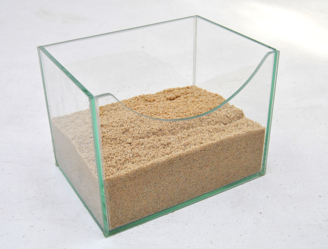 Glasbehälter mit feinem Sand, ideal für Kleintiere (Vögel/Nagetiere) zur Fellpflege, geschwungene Öffnung, gleichmäßig verteilt.