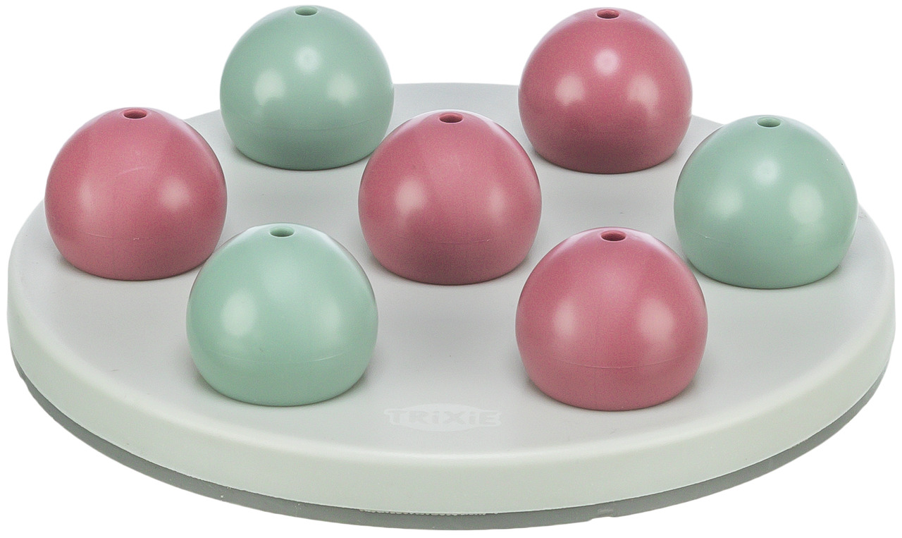 Das Bild zeigt das TRIXIE Dog Activity Strategiespiel, ein interaktives Spielzeug für Hunde. Es besteht aus einer runden, grauen Basis mit sieben abnehmbaren Kugeln in Rosa und Grün, die als Verstecke für Leckerlis dienen. Zielgruppe sind Hunde aller Größ