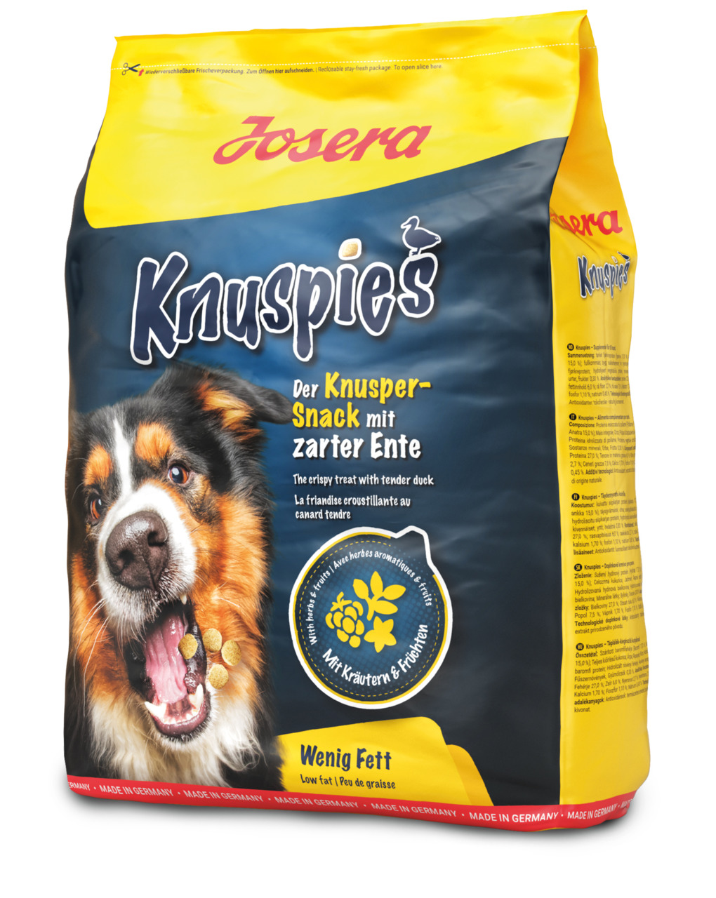 Josera Knuspies Hundesnack, zarte Ente, mit Kräutern & Früchten, wenig Fett, gelb-blaue Packung, fröhlich fressender Hund.