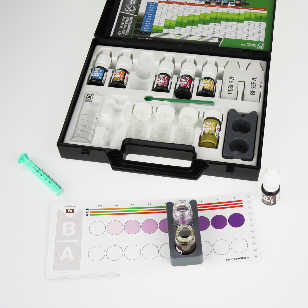 Das Bild zeigt das JBL ProAquaTest Lab, ein umfassendes Wassertest-Set für Aquarien und Teiche. Es enthält verschiedene Testfläschchen, Reagenzien, Messbehälter und eine Farbskala zur Analyse von Wasserparametern wie pH-Wert, Nitrat und Eisen. Zielgruppe 