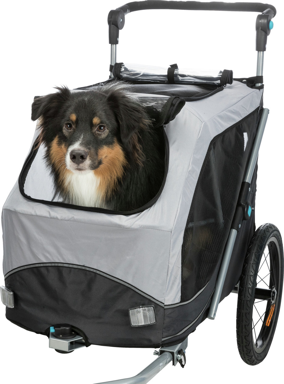 Das Bild zeigt einen TRIXIE Hundeanhänger in Grau und Schwarz, geeignet für mittelgroße Hunde. Der Anhänger bietet eine sichere und komfortable Transportmöglichkeit, ideal für Spaziergänge oder Fahrradtouren. Ein Australian Shepherd sitzt entspannt im Anh