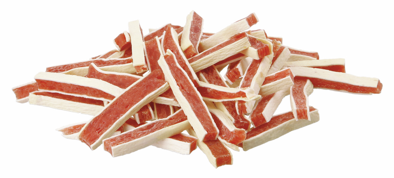 Ein Stapel von TRIXIE Premio Chicken Stripes, einem hochwertigen Hundesnack für ausgewachsene Hunde. Die Streifen bestehen aus Hühnerfleisch und Fischhaut, bieten eine schmackhafte Kombination und sind ideal als Belohnung. Verpackungsmenge: 100 g. Perfekt