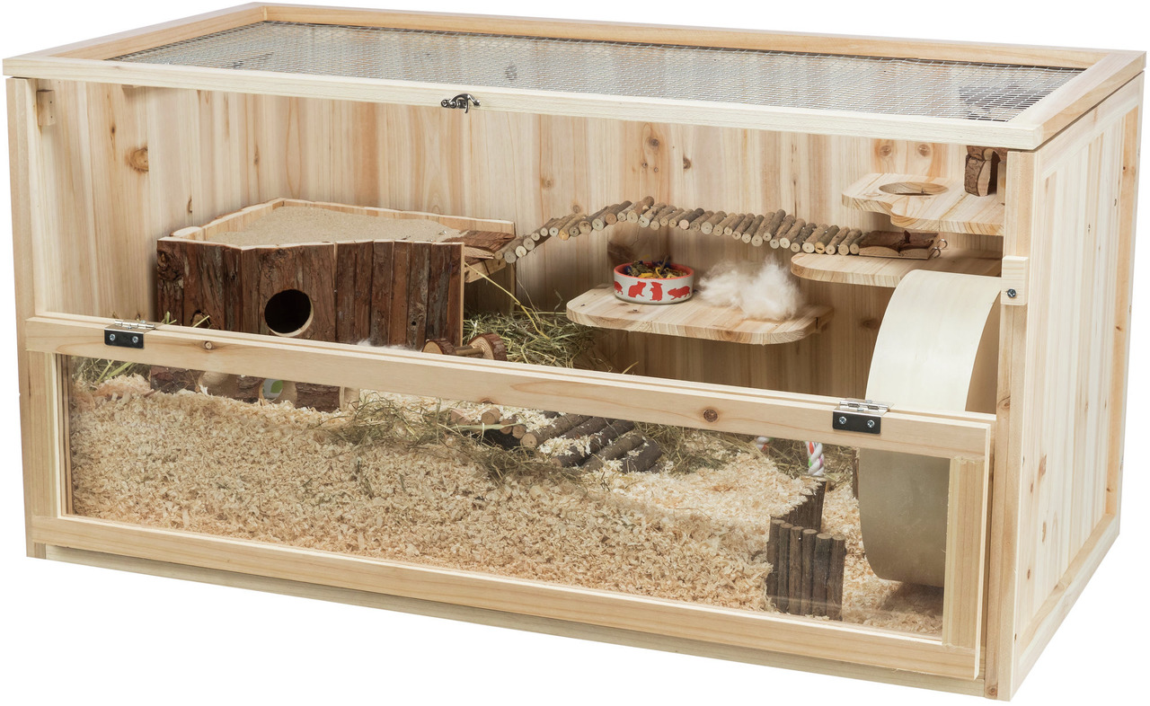 Das Bild zeigt den TRIXIE Kleintierkäfig aus Holz, geeignet für Hamster und andere Kleinnager. Der Käfig bietet mehrere Ebenen, eine Laufradfläche, eine Holzbrücke, ein Häuschen und eine Futterschale. Die Front besteht aus Glas, während die Oberseite mit 