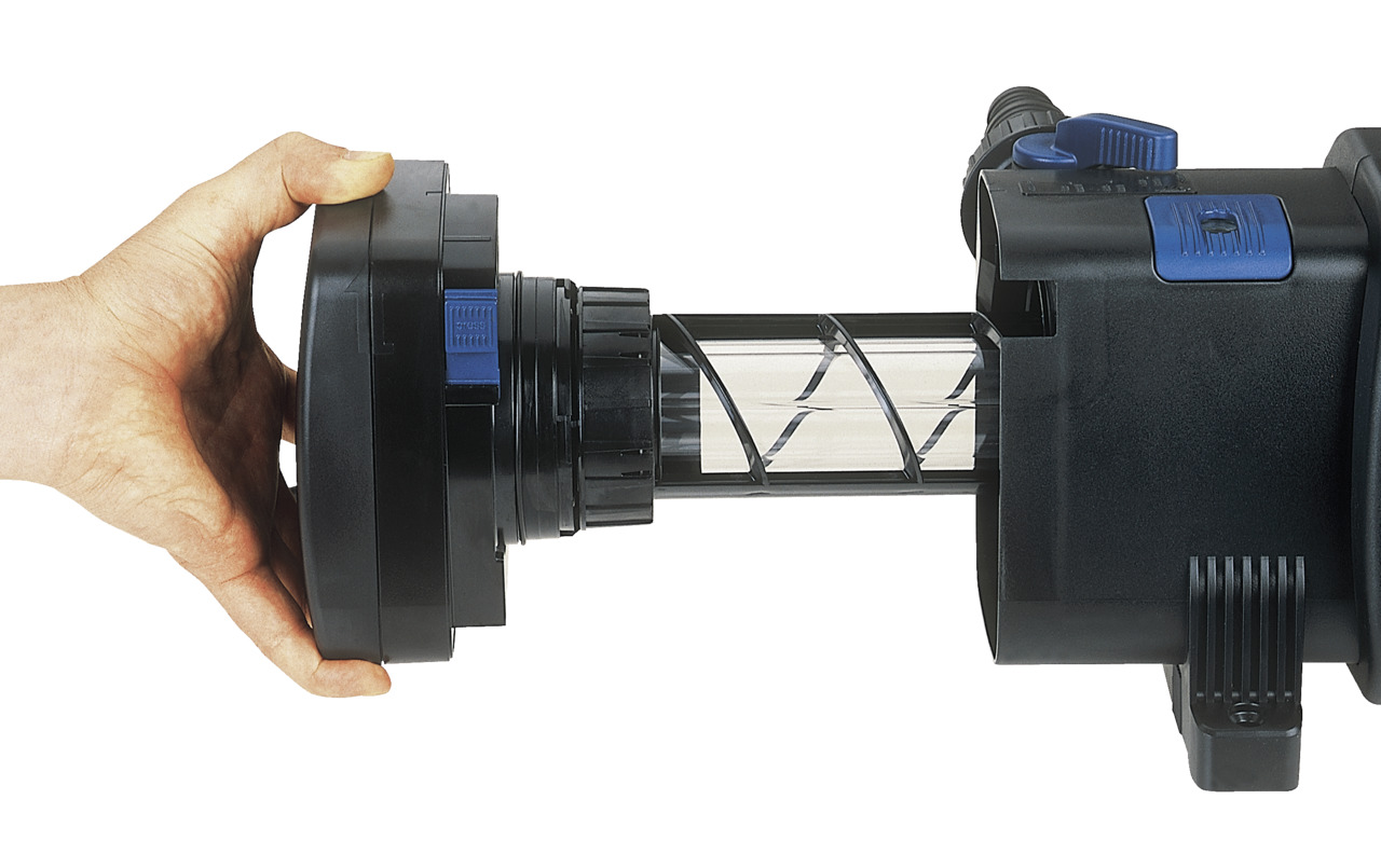 Das Bild zeigt den Oase Bitron 36C UVC-Klärer, ein hochwertiges Produkt für die Teichpflege. Es ist für Teichbesitzer geeignet und dient der effektiven Algenreduktion sowie der Verbesserung der Wasserqualität. Zu sehen ist eine Hand, die den Klärer öffnet