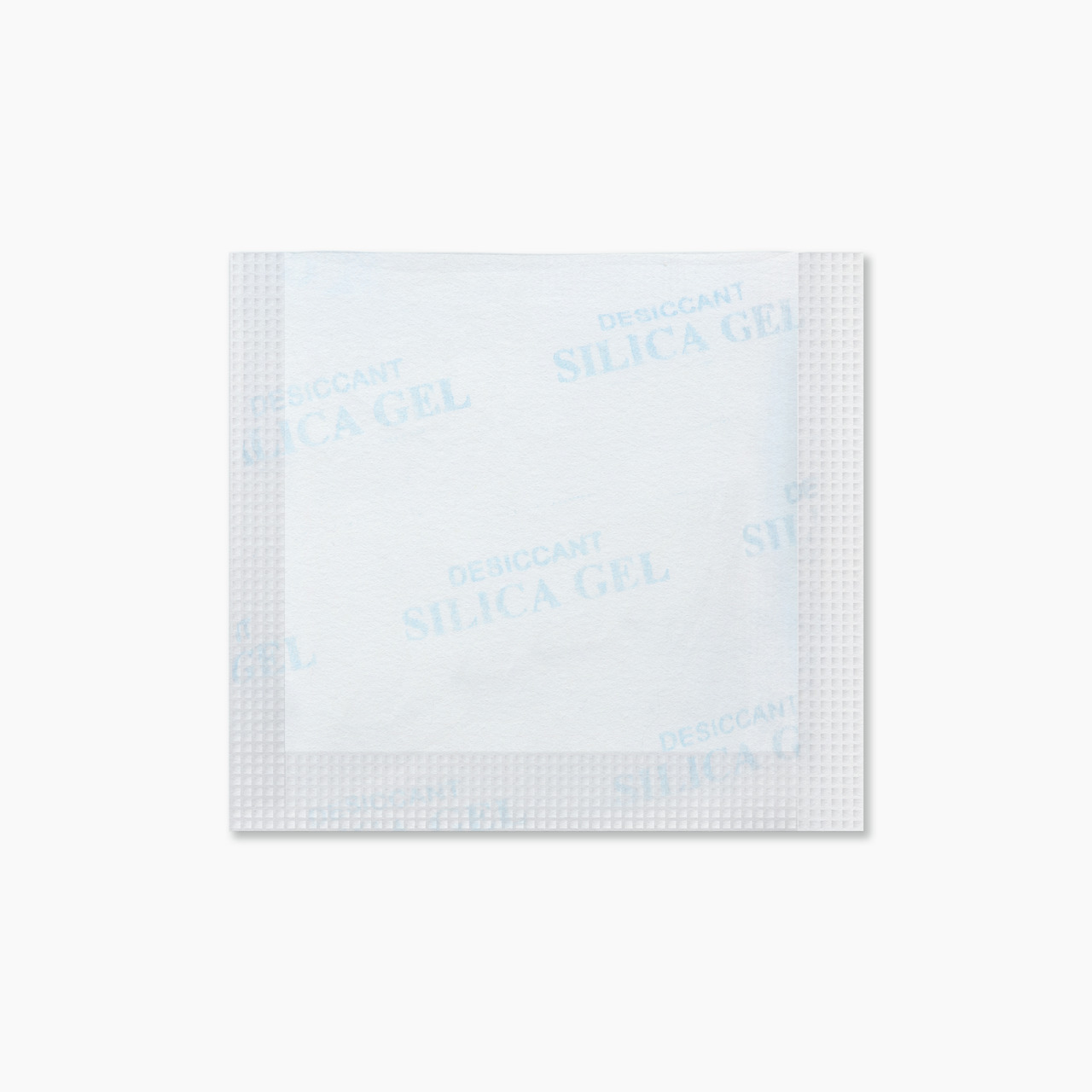 Rechteckiges Silica-Gel-Päckchen „DESICCANT SILICA GEL“, weiß mit blauer Aufschrift, dient zur Feuchtigkeitsaufnahme, z. B. für Elektronik.
