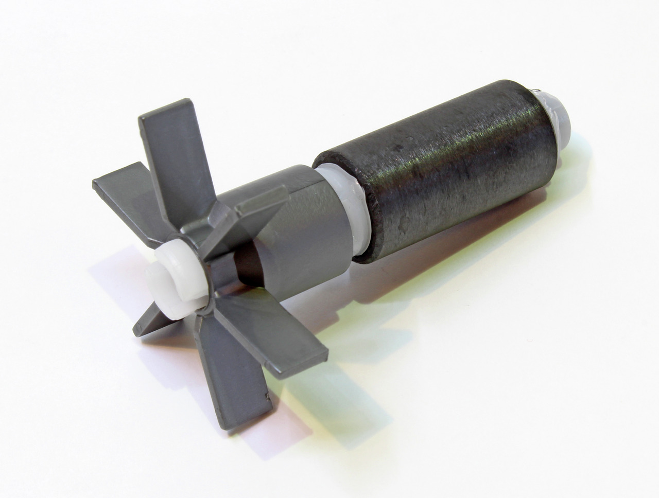 Das Bild zeigt ein Ersatzteil der Marke EHEIM, speziell einen Pumpenrotor für Aquarienfilter. Der Rotor besteht aus einem schwarzen Zylinder und grauen Flügeln, die für die Wasserzirkulation im Filter sorgen. Dieses Produkt richtet sich an Aquarienbesitze