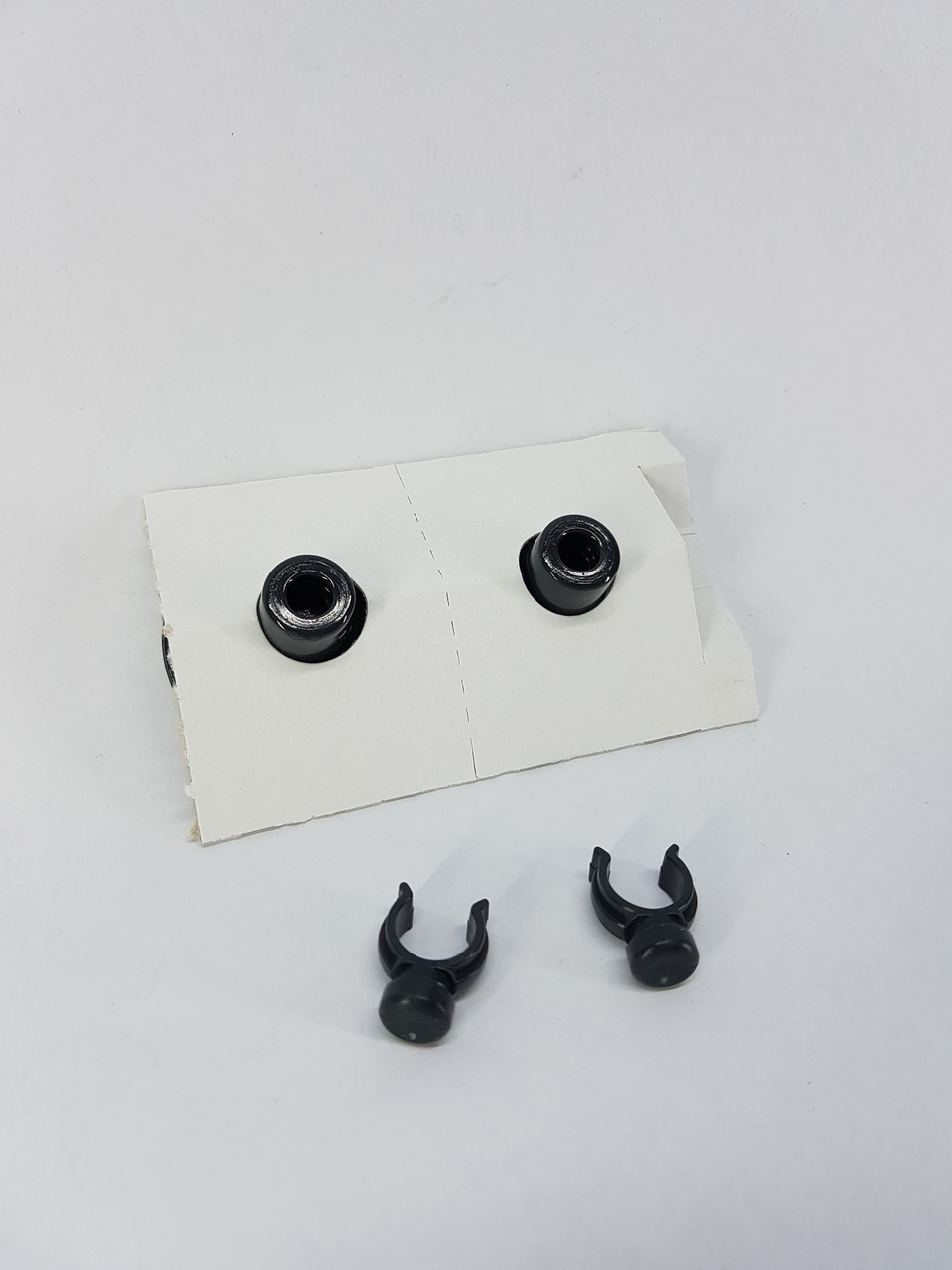 Das Bild zeigt das EHEIM Ersatzteil-Set mit der EAN 4011708400913. Es enthält zwei schwarze Saugnäpfe und zwei Clips, die auf einer weißen Kartonunterlage präsentiert werden. Dieses Zubehör ist speziell für Aquarien geeignet und dient der sicheren Befesti