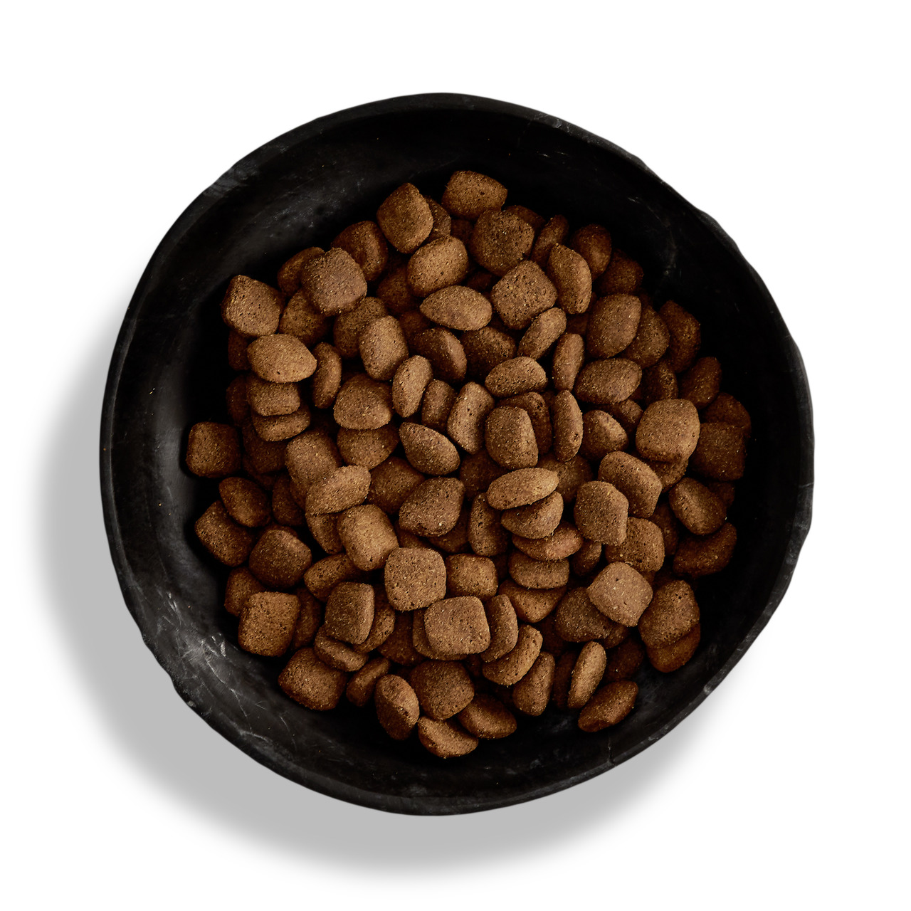 Canagan Premium-Hundefutter, getreidefrei, für Hunde, im Napf mit braunen Trockenfutterstücken, Geschmacksrichtung nicht angegeben.