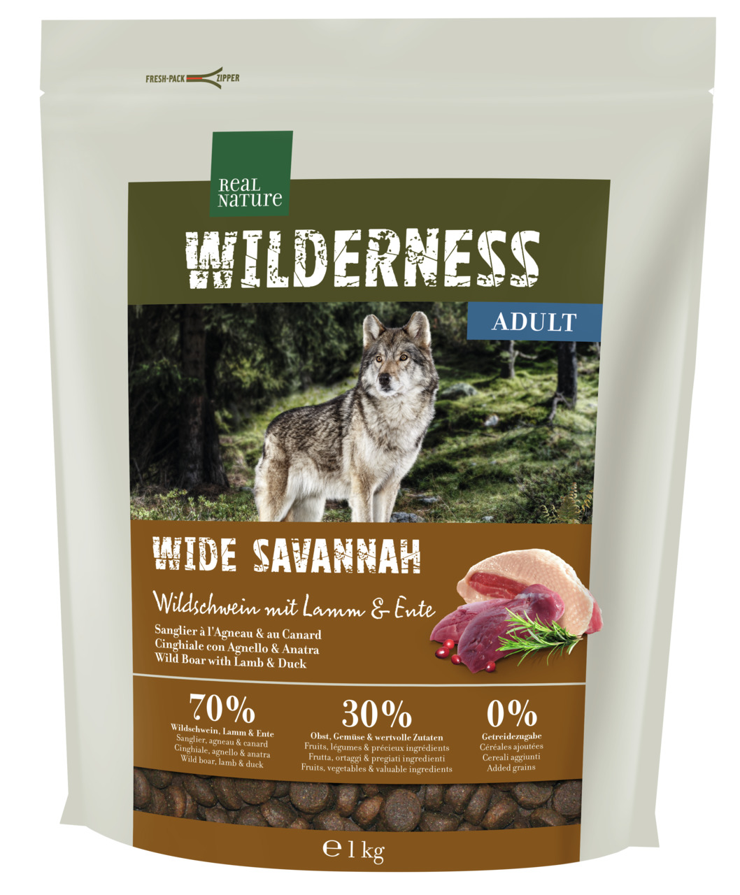 Das Bild zeigt eine Verpackung des Hundefutters „REAL NATURE WILDERNESS Wide Savannah“ für erwachsene Hunde. Die Geschmacksrichtung ist Wildschwein mit Lamm und Ente. Die Rezeptur besteht zu 70 % aus tierischen Zutaten, 30 % aus Obst und Gemüse und enthäl
