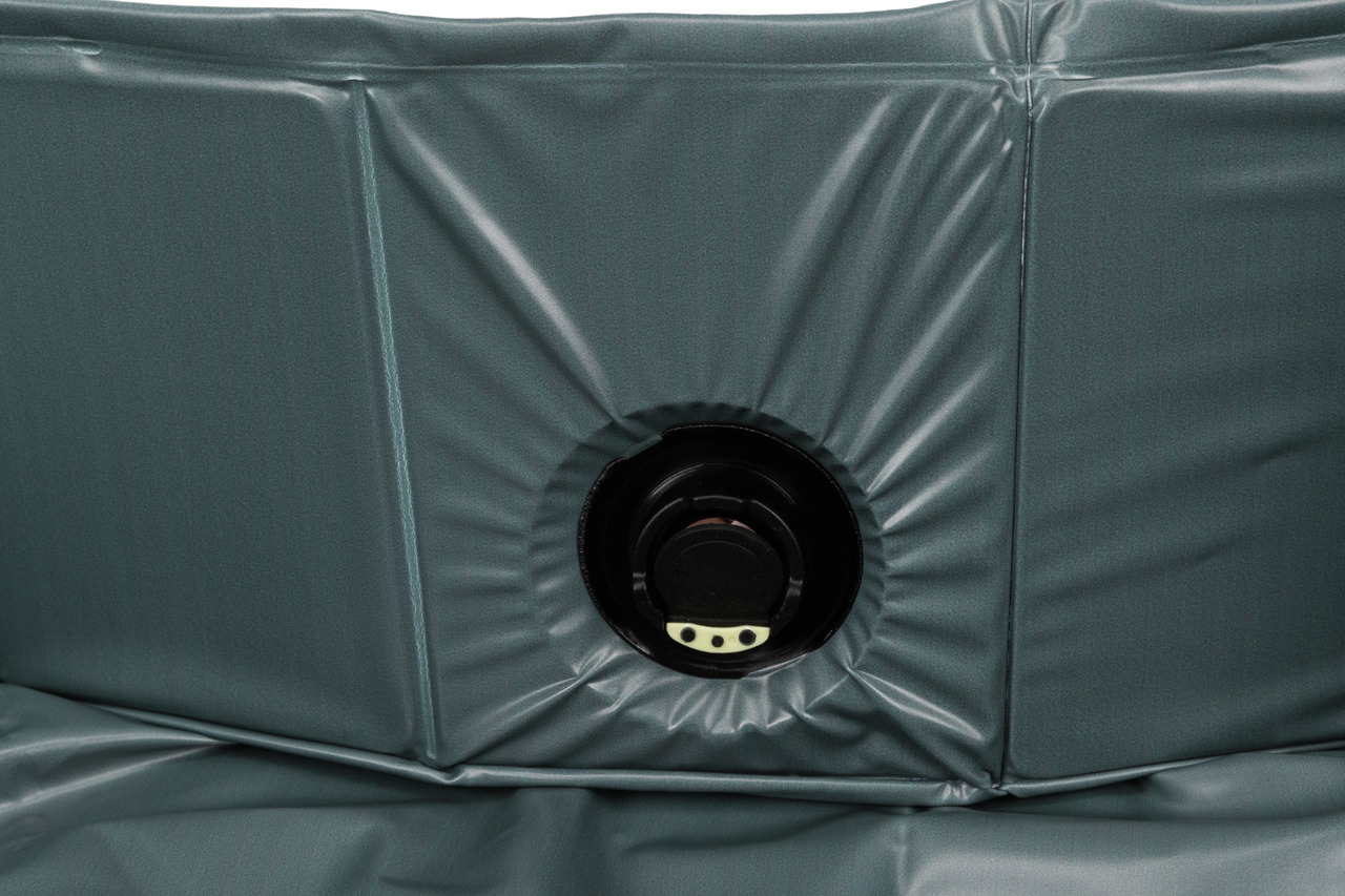 Das Bild zeigt ein Detail des TRIXIE Hundepools, erkennbar an der robusten, grauen PVC-Oberfläche und dem integrierten Wasserablassventil. Der Pool ist speziell für Hunde entwickelt und eignet sich ideal zur Abkühlung an heißen Tagen. Die abgebildete Größ