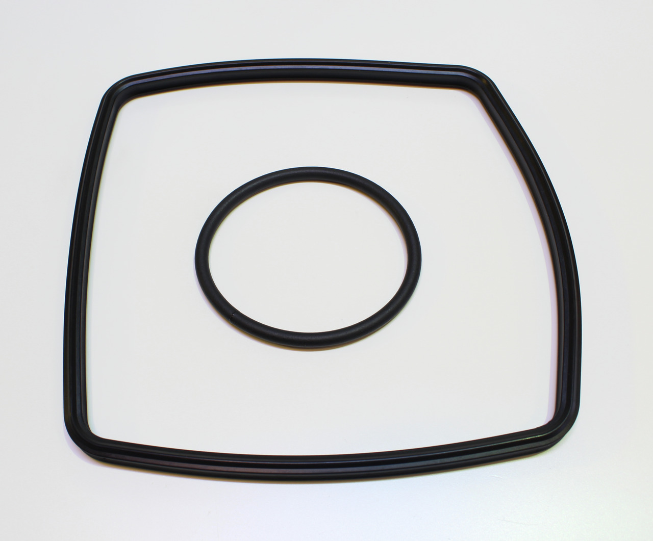Auf dem Bild sind zwei schwarze Dichtungsringe der Marke EHEIM zu sehen. Der größere Ring hat eine quadratische Form mit abgerundeten Ecken, während der kleinere Ring rund ist. Diese Ersatzteile sind für EHEIM-Aquarienfilter geeignet und dienen zur Abdich