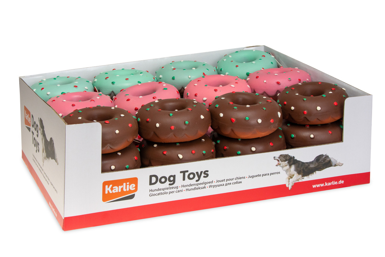 Das Bild zeigt eine Verpackung mit Hundespielzeug der Marke Karlie. Die Box enthält mehrere Donut-förmige Spielzeuge in verschiedenen Farben, darunter Braun, Rosa und Grün, mit bunten Punkten. Zielgruppe sind Hunde. Die Spielzeuge sind robust und ideal fü