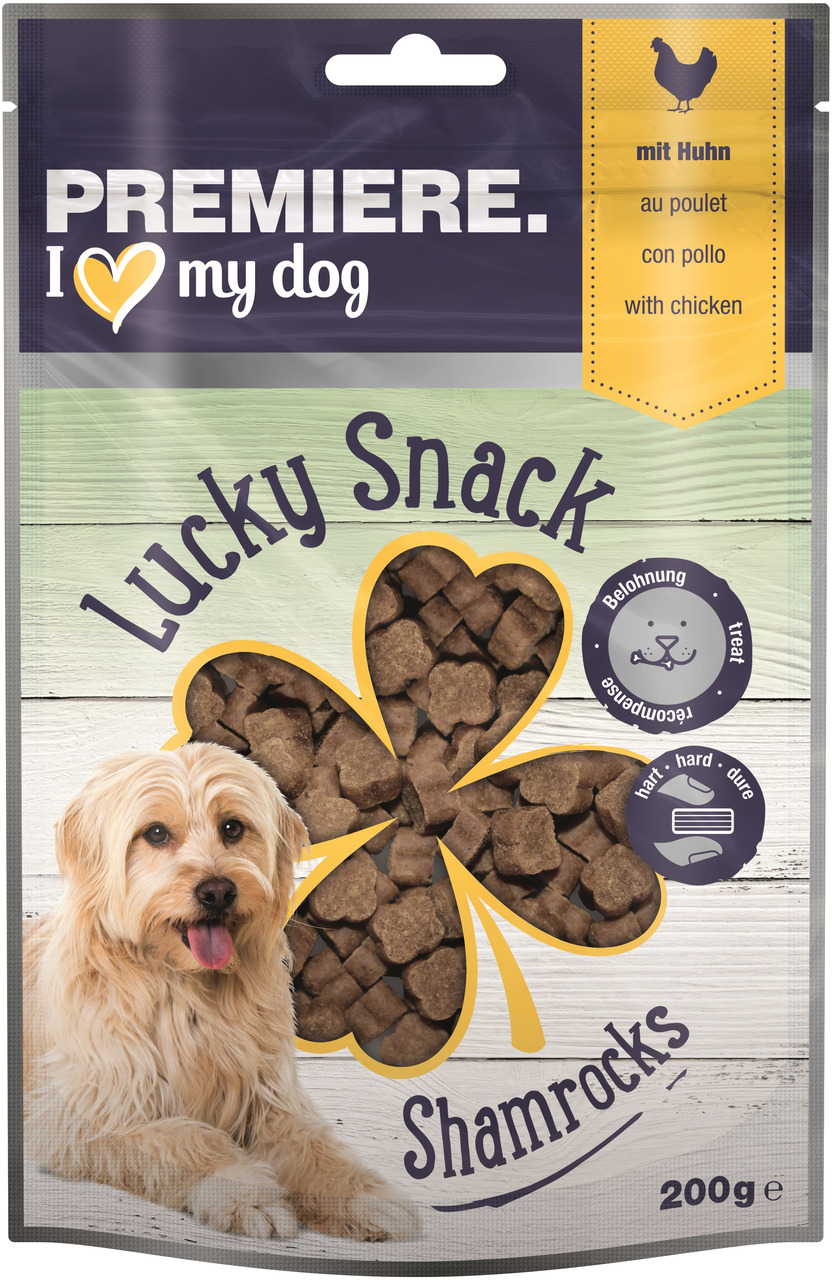 Das Bild zeigt eine Verpackung des Produkts "PREMIERE Lucky Snack Shamrocks" für Hunde. Die Zielgruppe sind Hundehalter, die ihren Hunden einen leckeren Snack bieten möchten. Die Geschmacksrichtung ist Huhn, und die Verpackung enthält 200 g. Der Snack wir