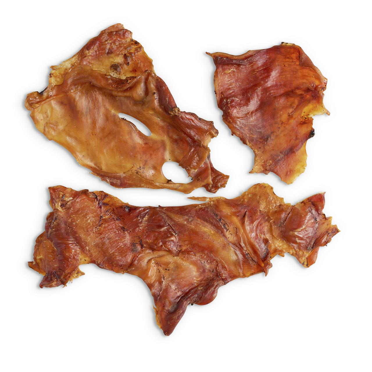 Das Bild zeigt drei getrocknete Rinderkopfhaut-Stücke der Marke Lottis Häppchen, ein natürlicher Kausnack für Hunde. Die Zielgruppe sind Hunde aller Größen, die Geschmacksrichtung ist Rind. Die Stücke sind goldbraun, knusprig und dienen der Zahnpflege sow