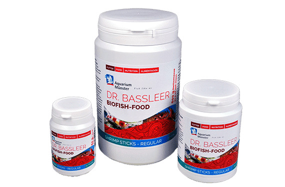 Das Bild zeigt drei weiße Dosen des Fischfutters „Dr. Bassleer Biofish Food Shrimp Sticks – Regular“ der Marke Aquarium Münster. Die Zielgruppe sind Aquarienbesitzer, speziell für Garnelen. Die Dosen sind in verschiedenen Größen abgebildet. Das Produkt ve