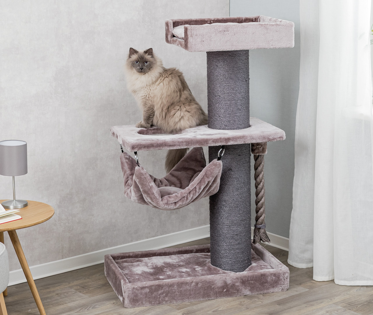 Das Bild zeigt den TRIXIE Kratzbaum „Lucano“, ein hochwertiges Produkt für Katzen. Der Kratzbaum ist in einem eleganten Grau gehalten und bietet mehrere Ebenen, darunter eine gemütliche Hängematte, eine Aussichtsplattform und eine robuste Sisalsäule zum K