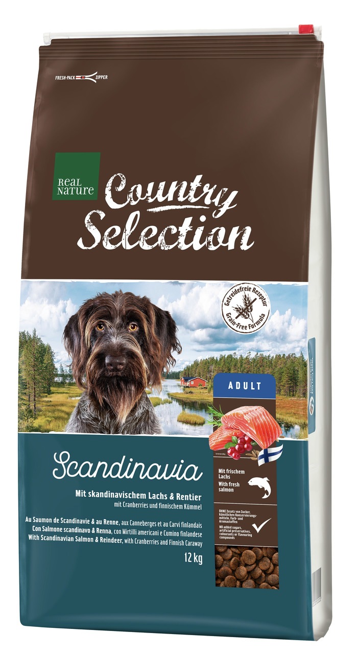 Das Bild zeigt einen 12-kg-Sack des Hundefutters „REAL NATURE Country Selection Scandinavia“. Es ist für ausgewachsene Hunde (Adult) geeignet und enthält skandinavischen Lachs und Rentier, verfeinert mit Cranberries und finnischem Kümmel. Die Verpackung h