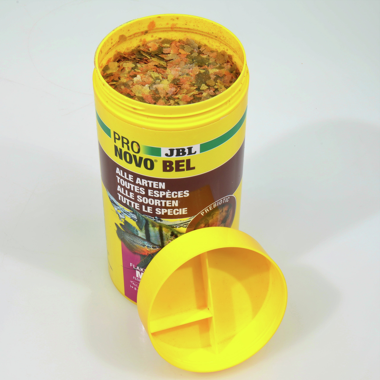 JBL Pro Novo Bel, Flockenfutter für alle Zierfische, 12 g, Geschmacksrichtung nicht spezifiziert, bunte Flocken, Deckel daneben.