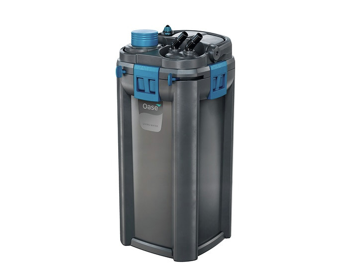 Das Bild zeigt den Oase BioMaster 600 Außenfilter, ein hochwertiges Filtersystem für Aquarien. Zielgruppe sind Aquarienbesitzer, die eine effiziente Wasserreinigung wünschen. Der Filter ist in einem modernen, grauen Design mit blauen Akzenten gestaltet. E