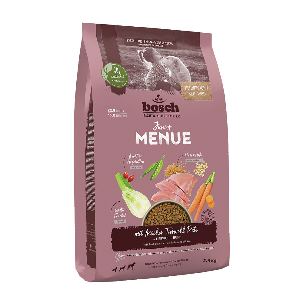 Das Bild zeigt eine 2,4 kg Packung des Hundefutters „bosch Junior Menue“ der Marke bosch Tiernahrung. Es ist speziell für heranwachsende Hunde geeignet und enthält frische Tierwohl-Pute und Huhn. Die Rezeptur umfasst Fenchel, Erbsen und Hirse, ist ohne Zu