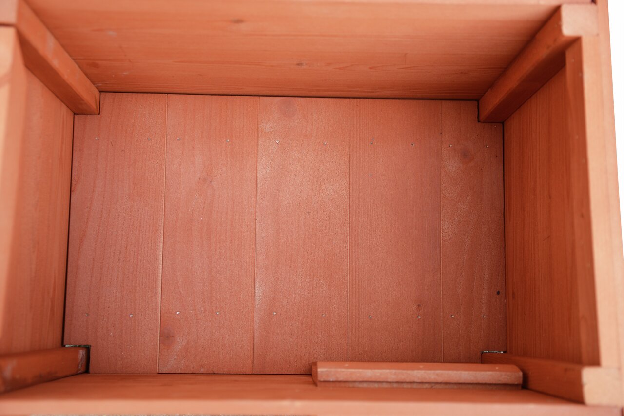Das Bild zeigt das Innere einer Holzkiste der Marke AK 4Pets, geeignet für Haustiere. Die Kiste besteht aus glattem, rotbraunem Holz mit sichtbaren Maserungen und Schrauben. Sie bietet eine robuste und sichere Aufbewahrungsmöglichkeit für Tierbedarf. Die 