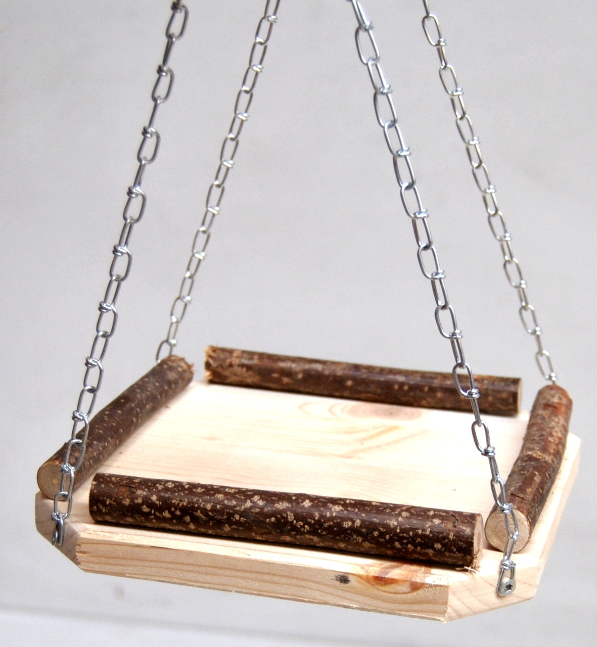Hängende Holzplattform von Ollesch, geeignet für Kleintiere wie Vögel oder Nagetiere. Die Plattform besteht aus naturbelassenem Holz mit seitlichen Ästen und wird von stabilen Metallketten getragen. Ideal als Sitz- oder Spielplatz. Maße und Gewicht sind n
