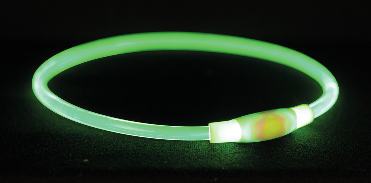 Leuchtendes, grünes LED-Halsband von TRIXIE für Hunde, ideal für Spaziergänge bei Dunkelheit. Das Halsband sorgt für bessere Sichtbarkeit und Sicherheit. Es ist flexibel, anpassbar und wiederaufladbar. Abgebildet ist ein Modell mit einer Länge von 70 cm. 