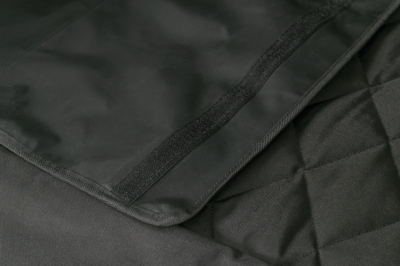 Das Bild zeigt eine schwarze, strapazierfähige Schutzdecke der Marke TRIXIE, geeignet für Hunde. Die Decke besteht aus robustem, wasserabweisendem Material und ist mit Klettverschlüssen ausgestattet, um sie sicher zu befestigen. Ideal für den Schutz von A