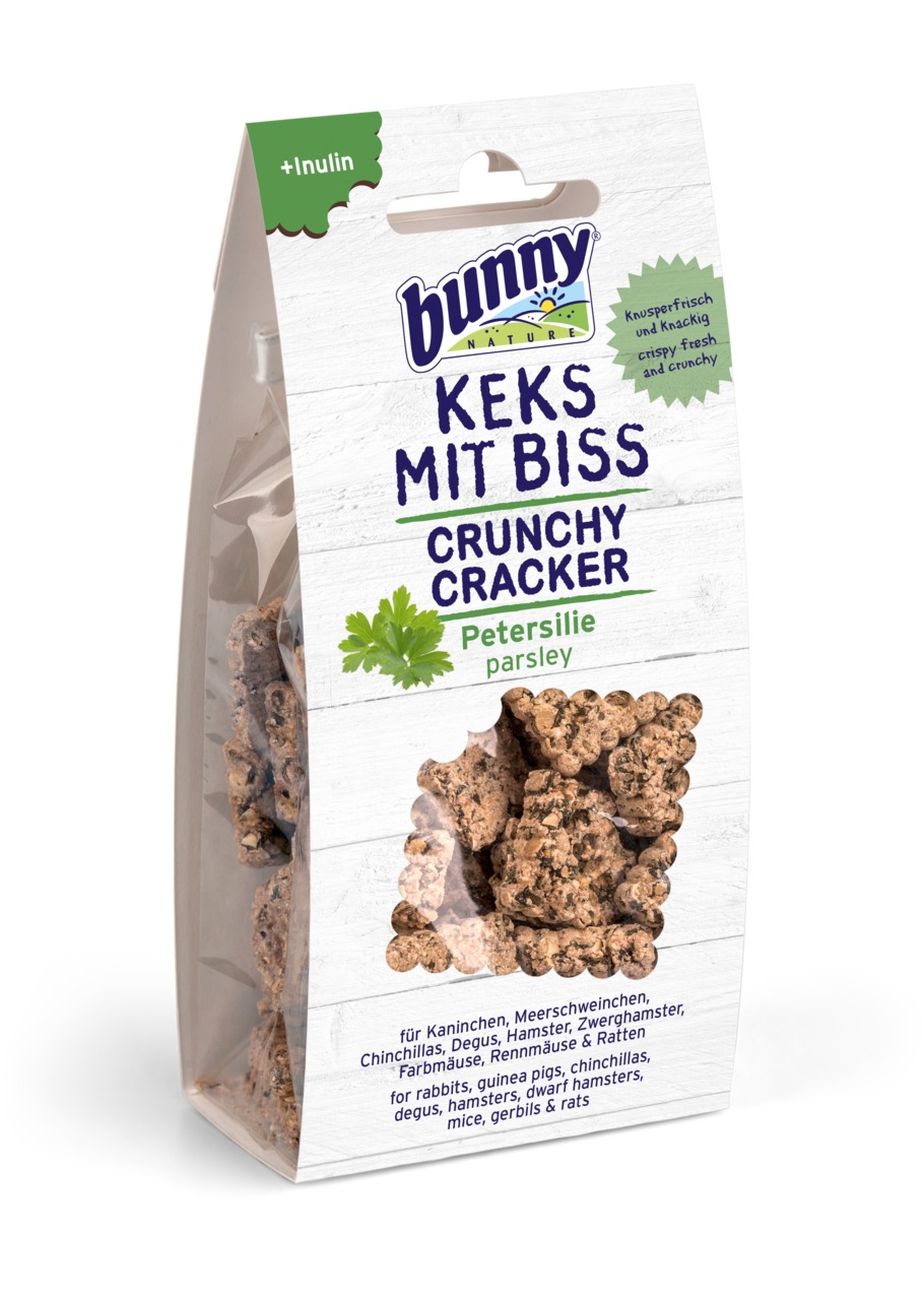 Das Bild zeigt eine Verpackung des Produkts „Bunny Nature Keks mit Biss Crunchy Cracker“ in der Geschmacksrichtung Petersilie. Die Zielgruppe sind Kaninchen, Meerschweinchen, Chinchillas, Degus, Hamster, Zwerghamster, Farbmäuse, Rennmäuse und Ratten. Die 