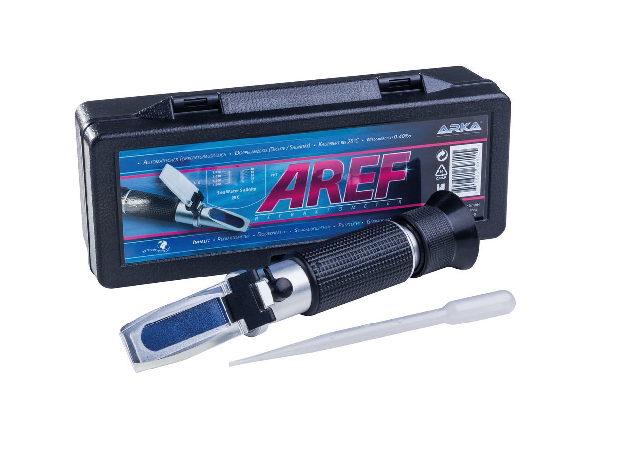 Das Bild zeigt das ARKA AREF Refraktometer, ein Präzisionsinstrument zur Messung der Salinität von Meerwasser. Es wird in einer schwarzen Kunststoffbox geliefert, die mit dem Produktnamen und technischen Details bedruckt ist. Enthalten sind das Refraktome