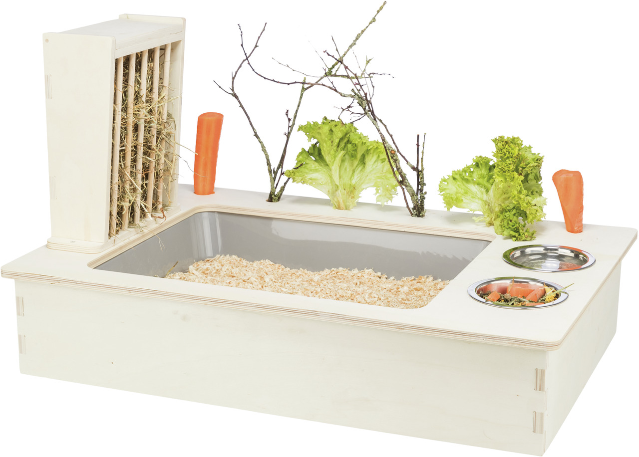 Das Bild zeigt das TRIXIE Kleintier-Futterstation-Set, ideal für Kaninchen und Meerschweinchen. Es besteht aus einer Holzbox mit integriertem Heuraufe, Futterschalen aus Edelstahl und Platz für frisches Gemüse wie Karotten und Salat. Die Station fördert a