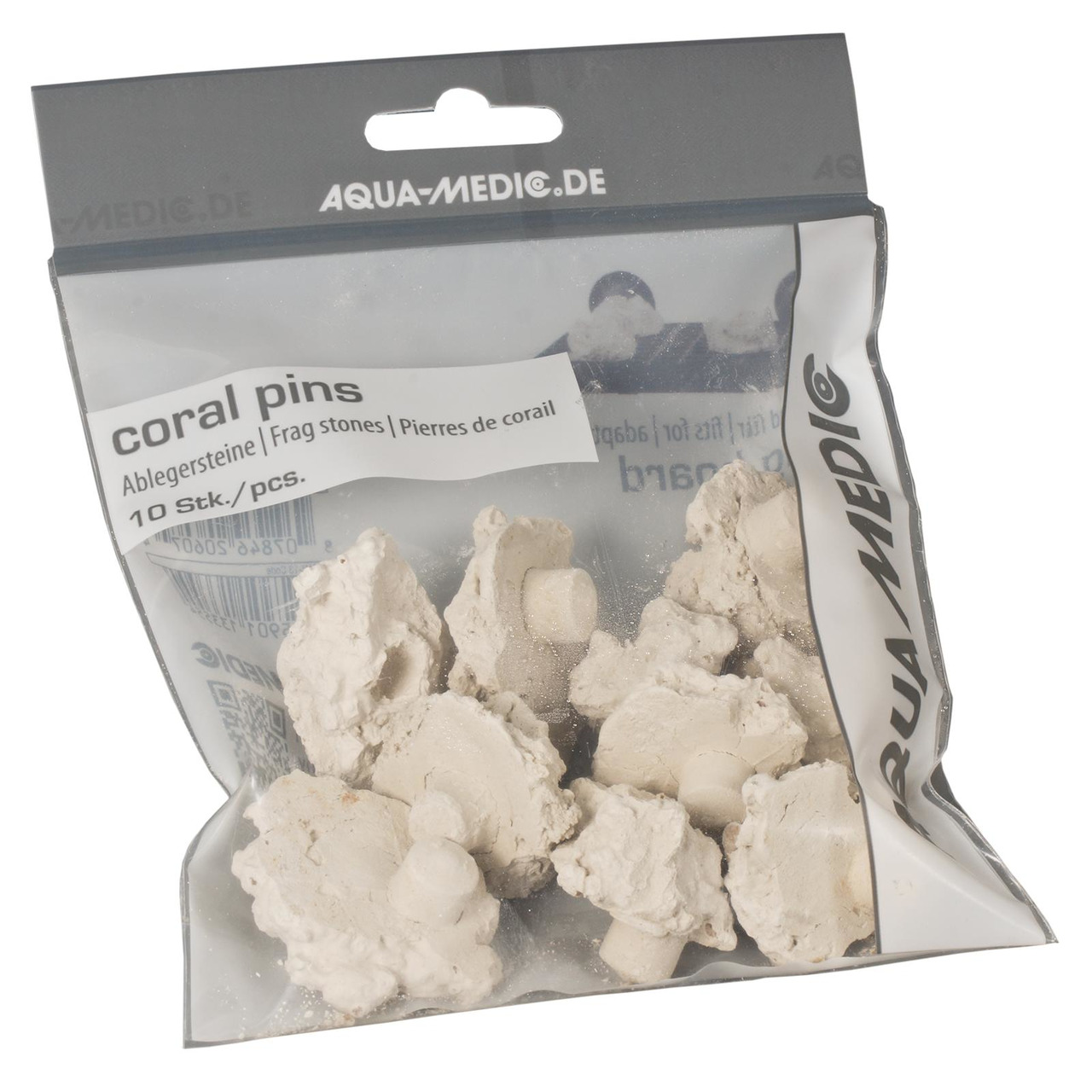 Das Bild zeigt eine durchsichtige Verpackung der Marke Aqua Medic mit der Aufschrift „coral pins“. Enthalten sind 10 Ablegersteine, die speziell für die Befestigung von Korallen in Aquarien entwickelt wurden. Die Steine sind weiß und unregelmäßig geformt.
