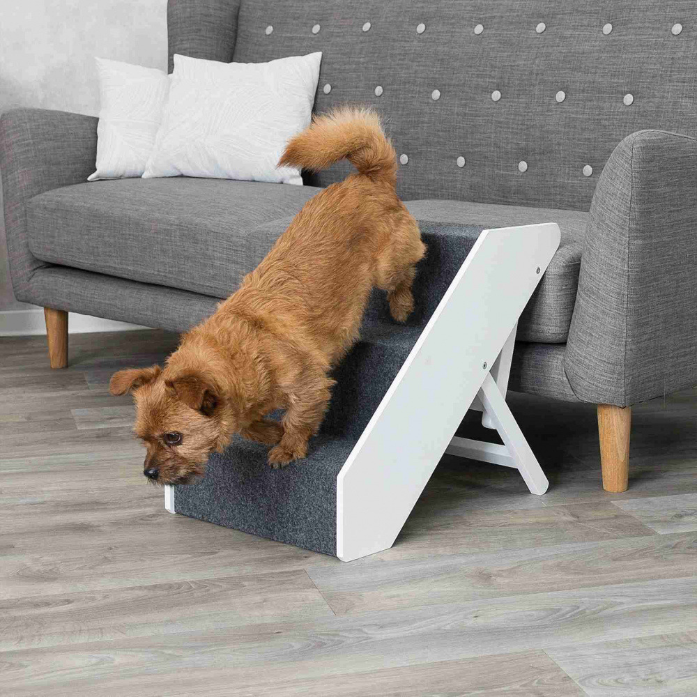 Das Bild zeigt die TRIXIE Haustiertreppe, ein praktisches Hilfsmittel für Hunde und Katzen, um Höhenunterschiede wie Sofas oder Betten sicher zu überwinden. Die Treppe ist weiß mit grauem Teppichbelag für besseren Halt. Sie eignet sich besonders für älter