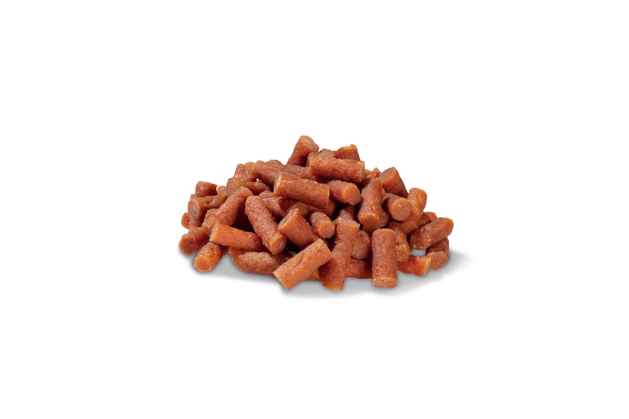 Ein Haufen PREMIERE Snack-Sticks für Hunde, erkennbar an ihrer rötlich-braunen Farbe und zylindrischen Form. Diese Leckerlis sind speziell für Hunde entwickelt und bieten eine schmackhafte Belohnung. Die Geschmacksrichtung ist Rind, und die Packungsgröße 