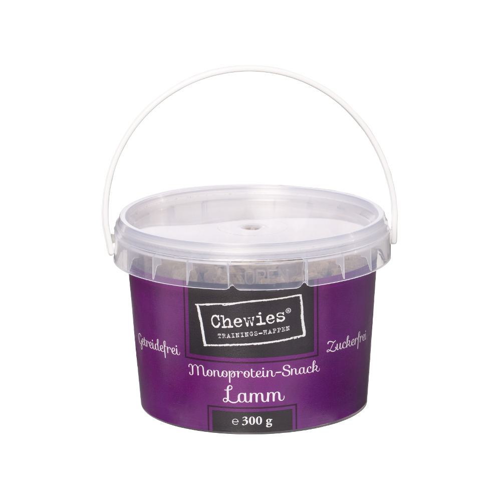 Das Bild zeigt einen violetten Kunststoffbehälter mit einem weißen Tragegriff, der das Produkt "Chewies Trainings-Happen Monoprotein-Snack Lamm" enthält. Die Verpackung ist mit den Angaben "getreidefrei" und "zuckerfrei" gekennzeichnet. Der Behälter hat e