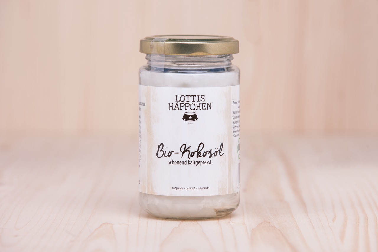 Ein Glas mit goldfarbenem Deckel, das „Lottis Häppchen Bio-Kokosöl“ enthält. Die Marke „Lottis Häppchen“ ist für Tierbedarf bekannt. Das Kokosöl ist schonend kaltgepresst, natürlich und artgerecht. Es eignet sich für Hunde und Katzen. Das Glas hat ein Fas