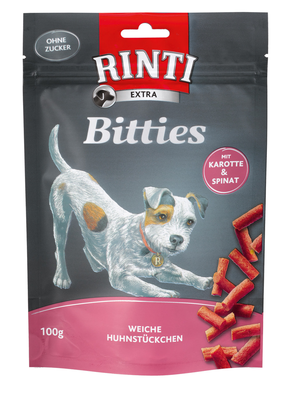 Das Bild zeigt eine Verpackung des Hundefutterprodukts „RINTI Extra Bitties“. Die Zielgruppe sind Hunde, und die Geschmacksrichtung ist Huhn mit Karotte und Spinat. Die Verpackung enthält 100 g weiche Huhnstückchen und wirbt mit „ohne Zucker“. Auf der Vor