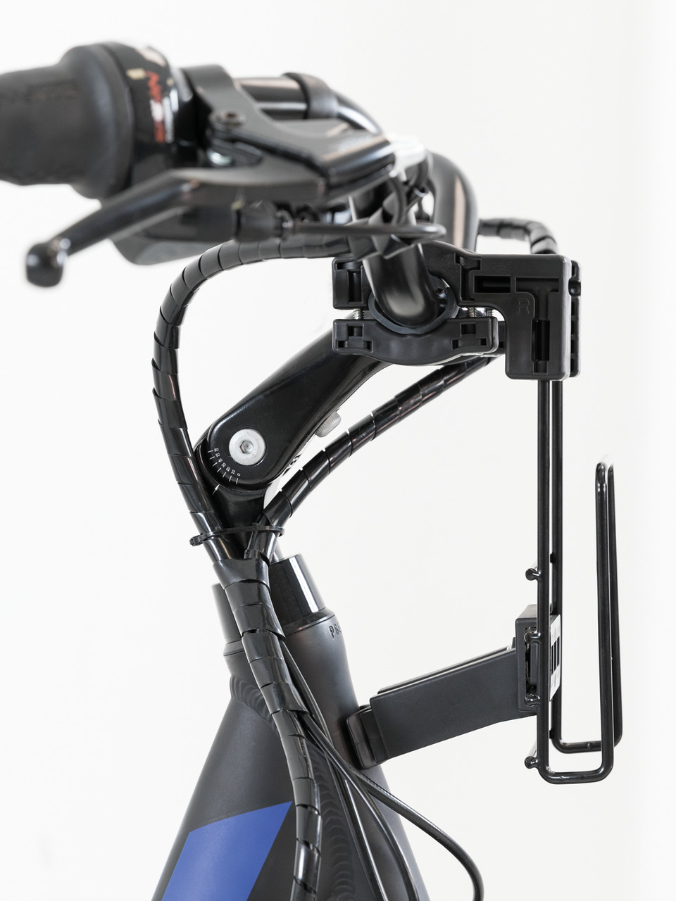 Das Bild zeigt eine Nahaufnahme eines Fahrradlenkers mit einer montierten Halterung, die speziell für die Befestigung eines TRIXIE Hunde-Fahrradkorbs entwickelt wurde. Die Halterung besteht aus robustem, schwarzem Metall und ist sicher am Lenker befestigt